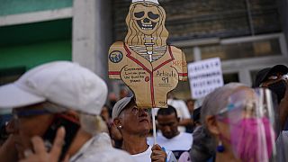 Un manifestante sostiene un esqueleto de cartón con el mensaje: "Las enfermeras luchan por un salario digno" durante una protesta de sanitarios públicos en Caracas, Venezuela.