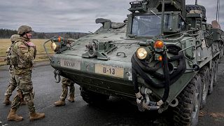 Soldiers of the 2nd Cavalry Regiment stand next to a Stryker combat vehicle in Vilseck, Germany, 9 February 2022