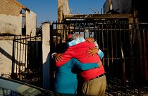 Residents embrace each other after a forest fire - made deadlier by climate change - reached their neighbourhood in Vina del Mar, Chile, 3 February 2024.