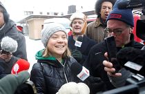 Climate activist Greta Thunberg reacts as she walks with members of the media during the World Economic Forum in Davos (WEF) in Davos, Switzerland