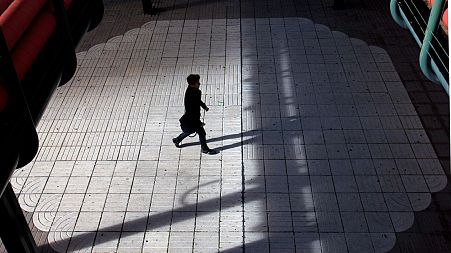 A man walks in the business district of Madrid in January 2013
