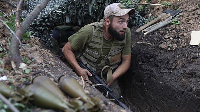 Um soldado ucraniano caminha ao longo de uma trincheira na região de Donetsk, na Ucrânia, a 15 de Agosto de 2022.