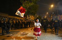 Γυναίκα φορώντας παραδοσιακή στολή και κρατώντας τη σημαία του Περού σε αντικυβερνητική διαδήλωση στη Λίμα 