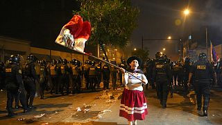 Γυναίκα φορώντας παραδοσιακή στολή και κρατώντας τη σημαία του Περού σε αντικυβερνητική διαδήλωση στη Λίμα 