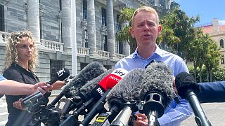 Chris Hipkins talks to reporters outside parliament in Wellington, New Zealand, Saturday, Jan. 21, 2022