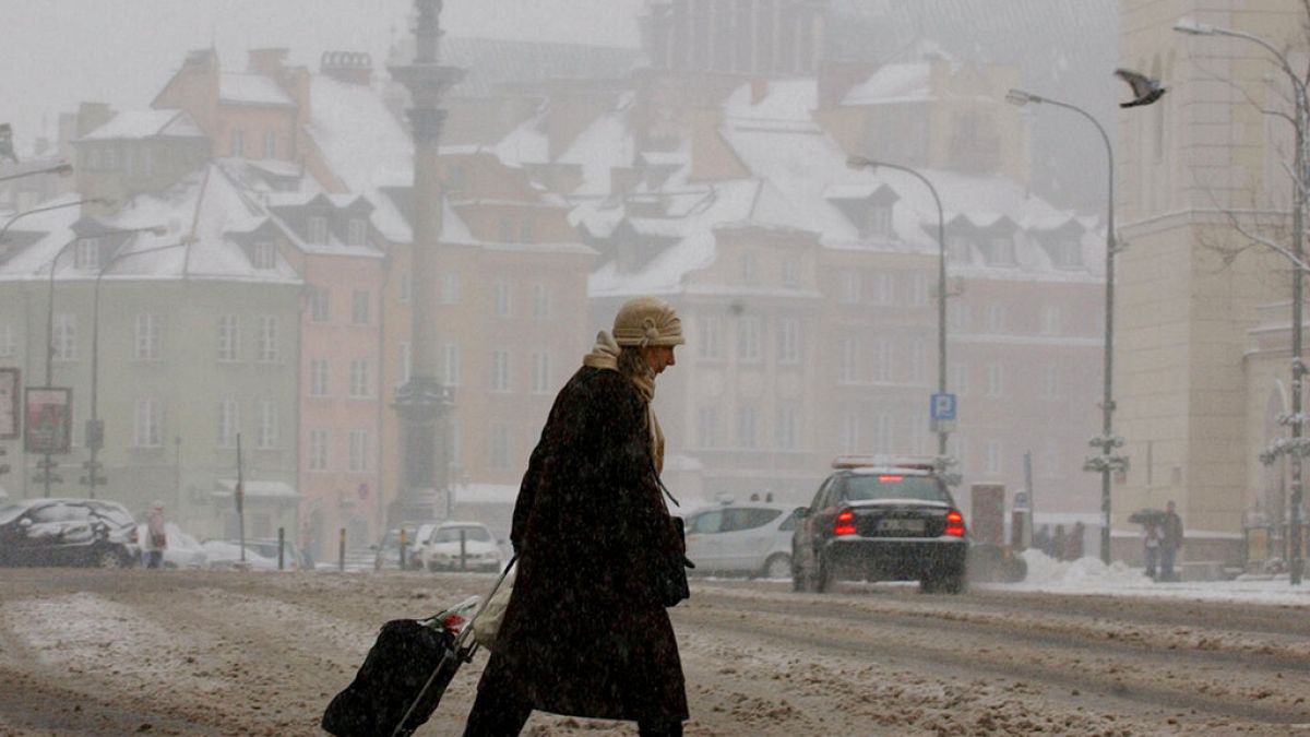 Eine Frau bahnt sich ihren Weg durch den Schneematsch im Zentrum von Warschau