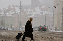 Eine Frau bahnt sich ihren Weg durch den Schneematsch im Zentrum von Warschau