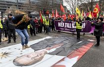 A protestor jumps on an image of Turkish President Recep Tayyip Erdogan during a demonstration organised by The Kurdish Democratic Society Centre in Sweden