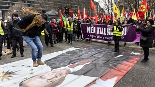 A protestor jumps on an image of Turkish President Recep Tayyip Erdogan during a demonstration organised by The Kurdish Democratic Society Centre in Sweden