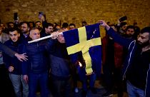 Demonstranten verbrennen die schwedische Nationalflaggevor dem schwedischen Generalkonsulat in Istanbul