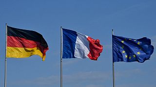The German, French and European Union flags flutter in the wind at the Chancellery in Berlin on April 29, 2019.