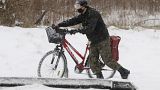 Un hombre empuja su bicicleta en medio del temporal en Polonia. 