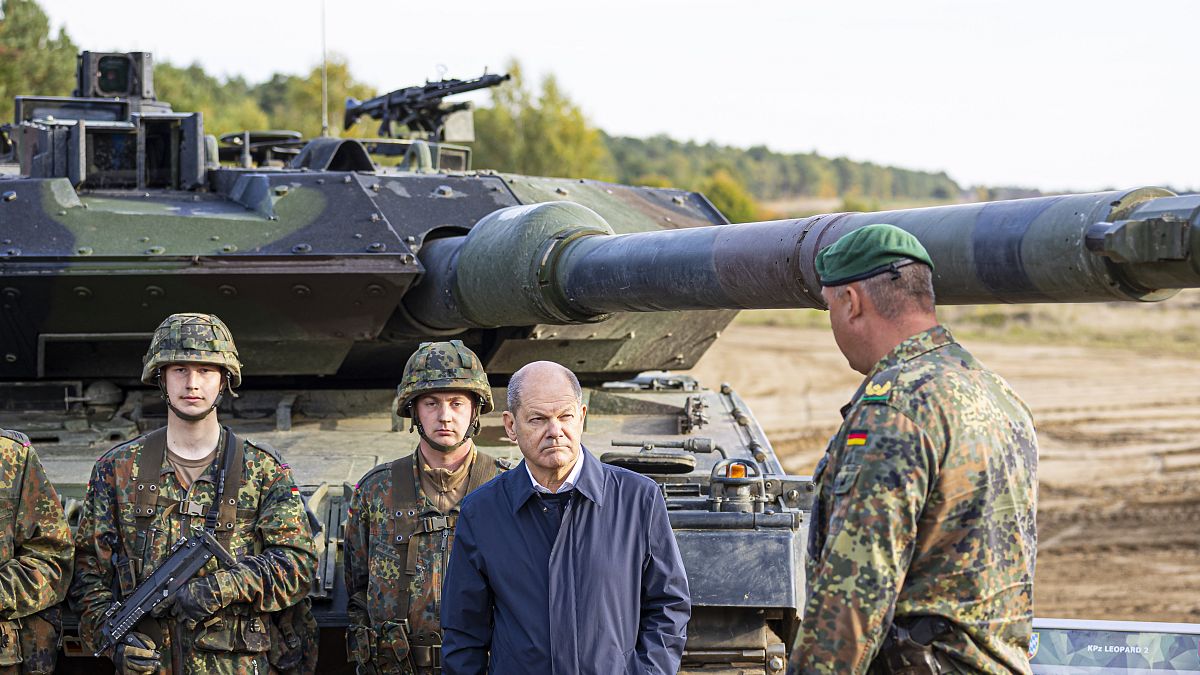 Olaf Scholz német kancellár német katonákkal egy Leopard 2-es típusú tank előtt