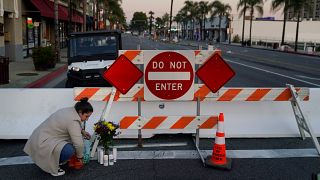 Woman leaves flowers in memory of those killed in California shooting.