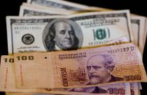 اسکناس یکصد پزویی آرژانتین در کنار اسکناس دلار آمریکا 