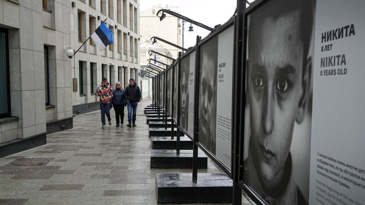 Pedestrians walk past the Estonian Embassy in Moscow