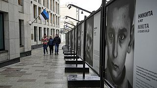 Pedestrians walk past the Estonian Embassy in Moscow