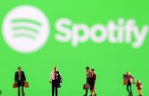 Small figurines displayed in front of the Spotify logo, February 11, 2022.