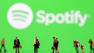Small figurines displayed in front of the Spotify logo, February 11, 2022.