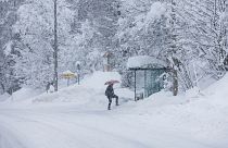 A person approaches a bus stop on a snow covered road in Kocevje, near Ljubljana Slovenia