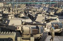 A soldier walks past a line of M1 Abrams tanks, Nov. 29, 2016, at Fort Carson in Colorado Springs, Colo