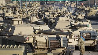 A soldier walks past a line of M1 Abrams tanks on November. 29, 2016, at Fort Carson in Colorado Springs, Colorado, US