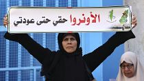 سيدة فلسطينية تحمل لافتة خلال مظاهرة خارج مقر وكالة الأمم المتحدة لإغاثة وتشغيل اللاجئين (الأونروا) في مدينة غزة ديسمبر 2022.