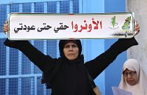 سيدة فلسطينية تحمل لافتة خلال مظاهرة خارج مقر وكالة الأمم المتحدة لإغاثة وتشغيل اللاجئين (الأونروا) في مدينة غزة ديسمبر 2022.