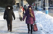 Phenjani lakosok sétálnak a hóban december 23-án