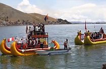 Members of Uru Indigenous community chant and wave Peruvian flags during a protest on boats                                                      floating in lake Titicaca