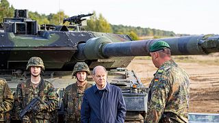 German Chancellor Olaf Scholz with a "Leopard 2" main battle tank during a training and instruction exercise in in Ostenholz, Germany, Oct. 17, 2022.