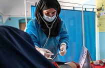 معاینه یک زن حامله افغان توسط کارمند زن یک نهاد غیردولتی بخش بهداشت و درمان
