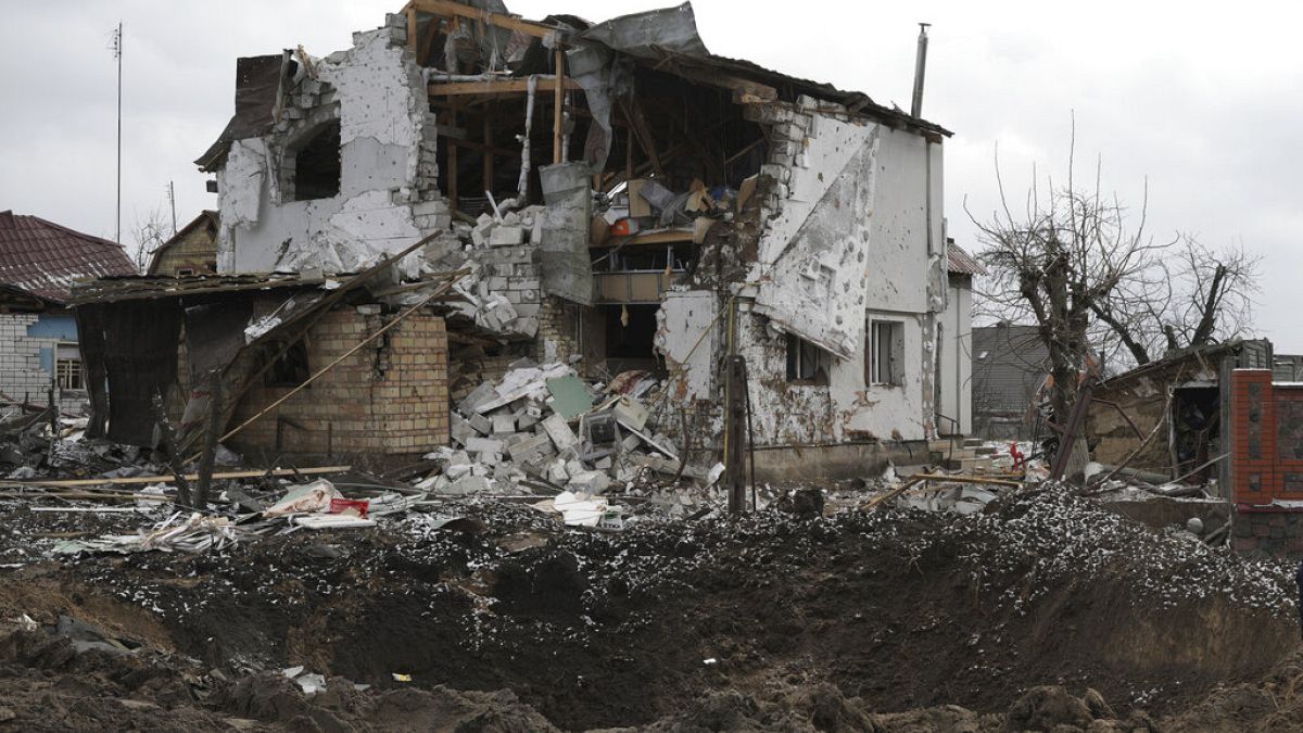 A crater of an explosion is seen next to a destroyed house after a Russian rocket attack in Hlevakha, Kyiv region, Ukraine, Thursday, Jan. 26, 2023.