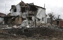 A crater of an explosion is seen next to a destroyed house after a Russian rocket attack in Hlevakha, Kyiv region, Ukraine, Thursday, Jan. 26, 2023.