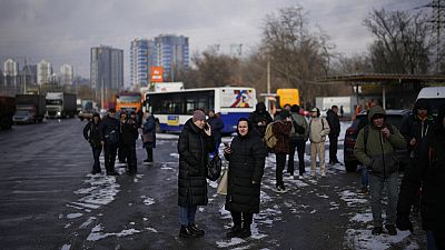 La gente espera en una calle bloqueada por la policía después de un ataque con cohetes en Kyiv, Ucrania, jueves 26 de enero de 2023.