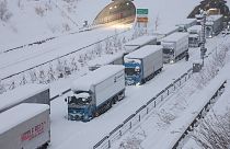 Des camions sont vus coincés en raison de la neige abondante sur la voie rapide Shin-Meishin à Yokkaichi, dans la préfecture de Mie, le 25 janvier 2023.