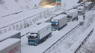 Des camions sont vus coincés en raison de la neige abondante sur la voie rapide Shin-Meishin à Yokkaichi, dans la préfecture de Mie, le 25 janvier 2023.