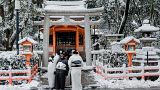 أشخاص يرتدون ملابس تقليدية أمام ضريح ياساكا في كيوتو بعد أن أثرت الثلوج الكثيفة والرياح العاتية خلال الليل على مناطق واسعة من البلاد، في 25 يناير 2023 