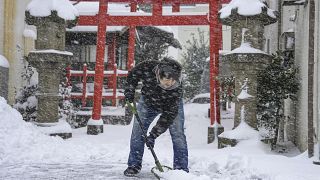 Una persona palea la nieve frente a un santuario el miércoles 25 de enero de 2023 en Tottori, prefectura de Tottori, oeste de Japón.
