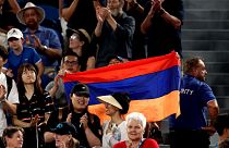 Spectator waves Armenia flag during the men's singles quarter-final match between USA's Sebastian Korda and Russia's Karen Khachanov on day nine of the Australian Open tennis