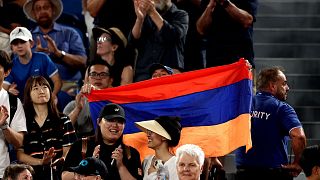 Spectator waves Armenia flag during the men's singles quarter-final match between USA's Sebastian Korda and Russia's Karen Khachanov on day nine of the Australian Open tennis