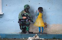 An artwork of the famous street artist TvBoy, in seen on the wall of the house of culture in the town of Irpin, outside Kyiv, Ukraine Monday, Jan. 30, 2023.