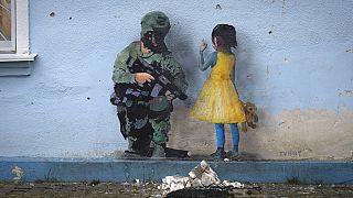 A pintura de um soldado e uma menina numa parede numa casa na Ucrânia
