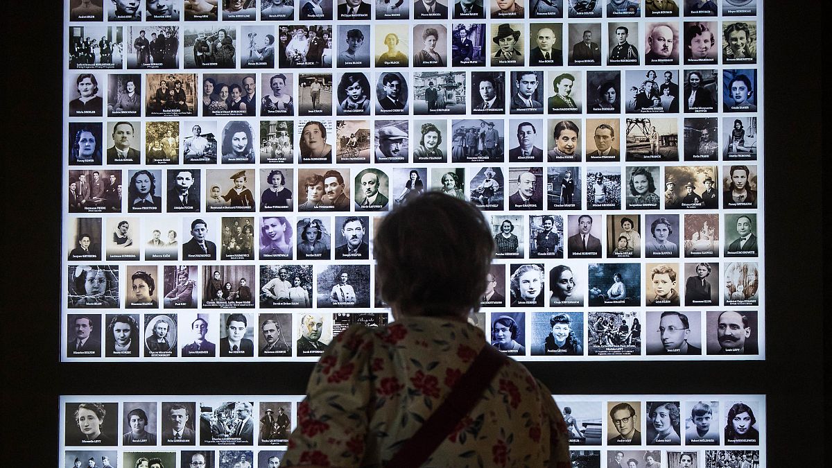 زائرة تنظر إلى صور لمئات ضحايا المحرقة، في متحف  لإحياء ذكرى المحرقة في مدينة بيتفييه، فرنسا 2022 
