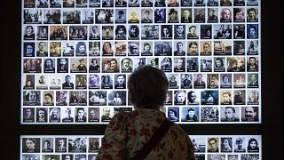 زائرة تنظر إلى صور لمئات ضحايا المحرقة، في متحف  لإحياء ذكرى المحرقة في مدينة بيتفييه، فرنسا 2022