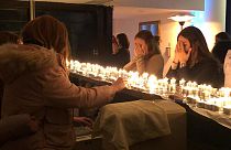 Jewish women gather to pray around candles.
