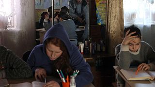 A group of Ukrainian students study in teacher’s living room in eastern Donetsk. 