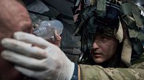 A military medic gives first aid to a soldier wounded in a battle near Kremenna in the Luhansk region, Ukraine, Jan. 16, 2023. 