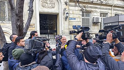 Újságírók az iráni nagykövetség előtt az azerbajdzsáni Bakuban 2023. január 27-én