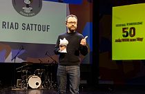 French comics writer Riad Sattouf poses on stage after receiving the 'Grand Prix' for his all work during the 50th Angouleme International Comics Festival